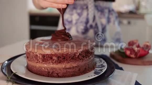 面包师用巧克力装饰巧克力蛋糕厨房烹饪蛋糕的过程视频的预览图