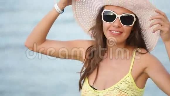 戴眼镜戴帽子的年轻女子在海边视频的预览图
