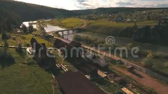 从森林附近的河流和村庄的高度鸟瞰视频的预览图