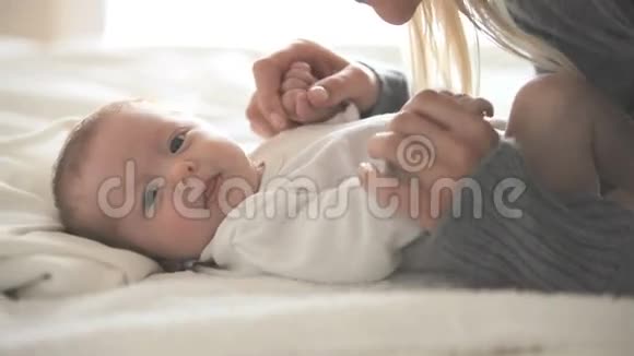 女人亲吻躺在床上的婴儿视频的预览图