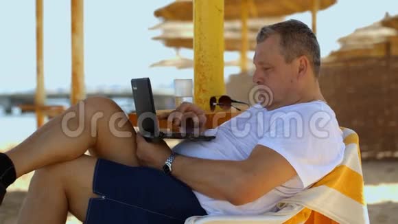 带笔记本电脑在海滩度假酒店放松视频的预览图