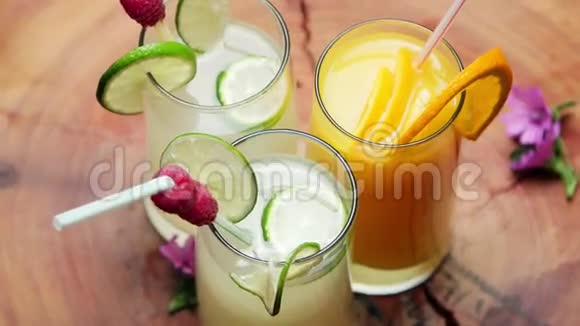一杯天然橙汁和两杯柠檬汁旋转视频的预览图