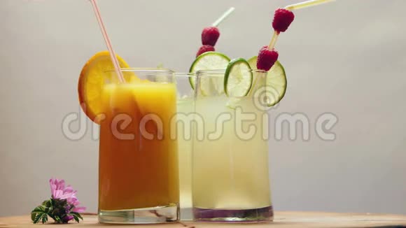 一杯天然橙汁和两杯柠檬汁旋转视频的预览图