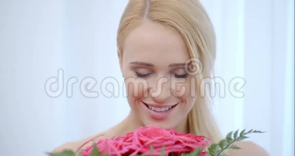 微笑金发女人微笑粉红玫瑰视频的预览图