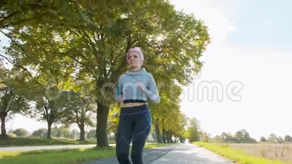 带粉红色头发的年轻女士在郊区慢跑故障视频的预览图