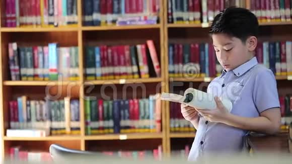 小亚洲男孩厌倦了阅读泰国图书馆视频的预览图