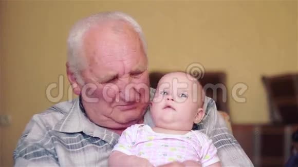 快乐的祖父手里拿着婴儿说话视频的预览图