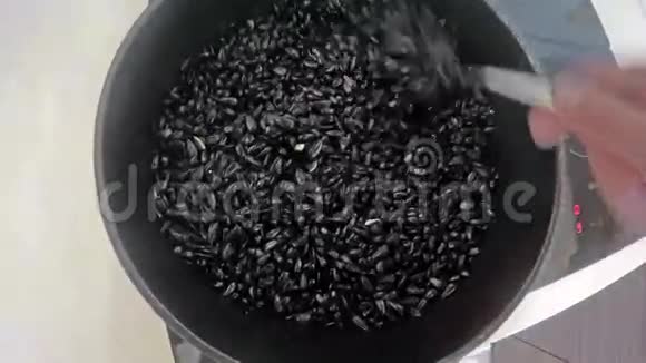 烤葵花种子用汤匙放入煎锅中视频的预览图