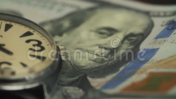 在一只漂亮的手表上合上时钟驱动器上的美元钞票视频的预览图