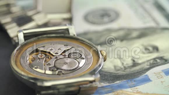在一只漂亮的手表上合上时钟驱动器上的美元钞票视频的预览图