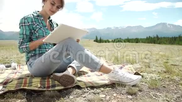 年轻的白种人深色头发漂亮的女人带着平板电脑坐在公园的楼梯上穿着休闲的现代服装视频的预览图