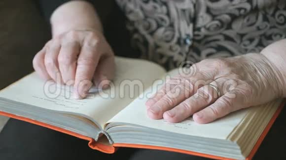 老妇人的旧手拿着一本书视频的预览图
