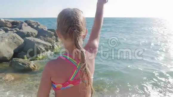 小女孩在海滩上快乐地玩波浪视频的预览图