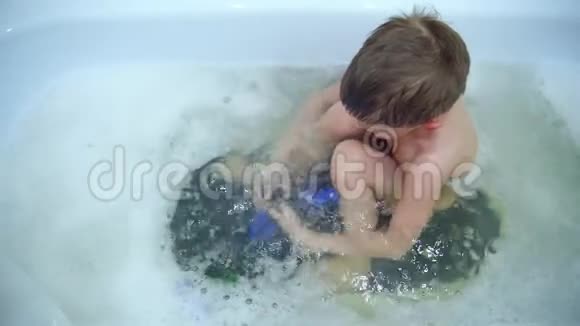 可爱的小男孩在浴室里玩视频的预览图