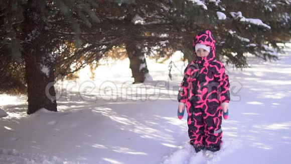 一个快乐的孩子穿着连衣裙玩雪慢动作视频的预览图
