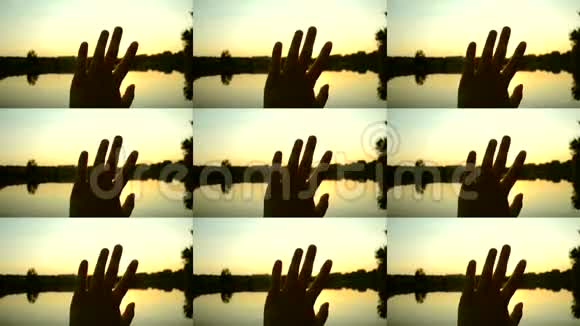 手的黑色轮廓通过手指的阳光在空中移动视频的预览图