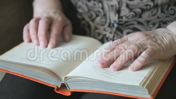 老妇人的旧手拿着一本书视频的预览图