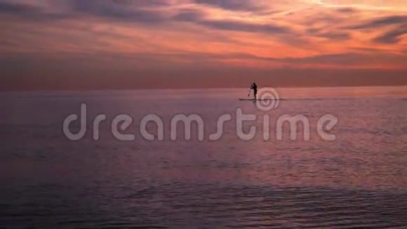 海上日落日落时冲浪板上的人海上日落日落景观视频的预览图