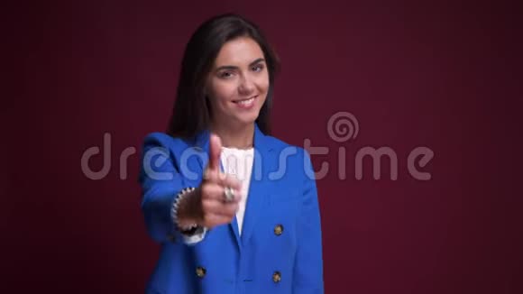 年轻活泼的白种人女性的特写镜头她的大拇指微笑着看着镜头视频的预览图