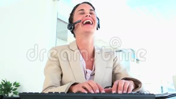 女人在键盘上取下耳机和打字视频的预览图