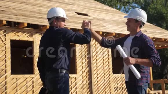 团队合作握手概念建筑构建建筑师慢动作视频两个戴头盔的人握手视频的预览图
