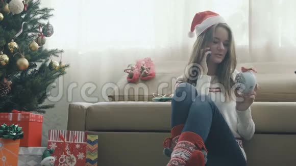 戴着圣诞帽的漂亮女孩在打电话视频的预览图