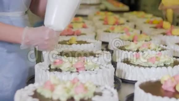 糖果手在传送带上装饰蛋糕蛋糕生产流程视频的预览图