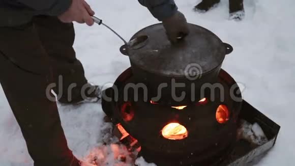 冬天游客在篝火旁烧锅做饭视频的预览图
