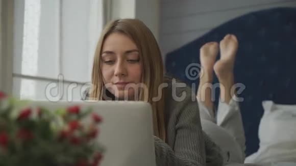 带着笔记本电脑躺在床上的金发美女视频的预览图