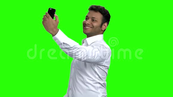 微笑的年轻人用手机自拍视频的预览图