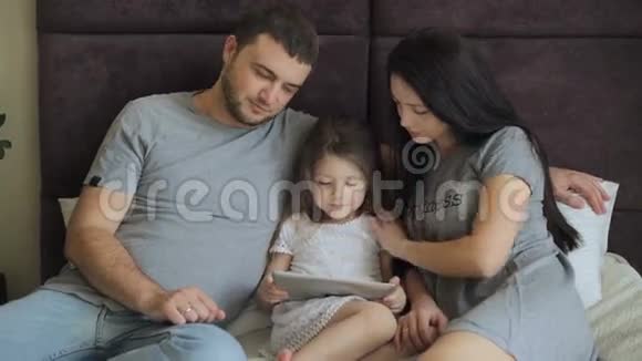 幸福的家庭躺在床上看着桌子视频的预览图