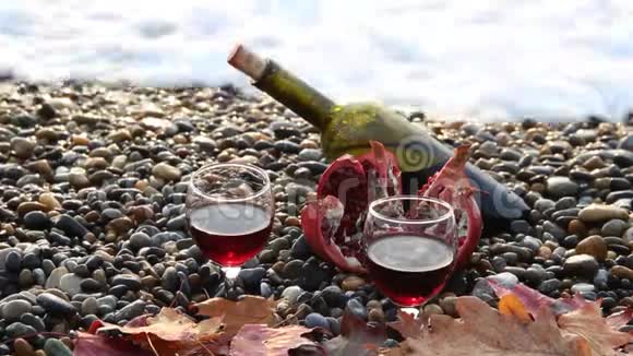 成熟的石榴果和沙滩上的一瓶视频的预览图