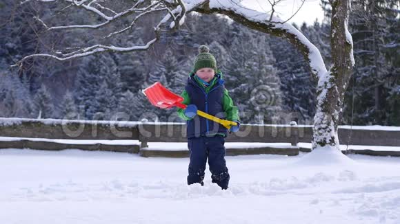 一个小男孩用雪铲缓慢地扔雪视频的预览图