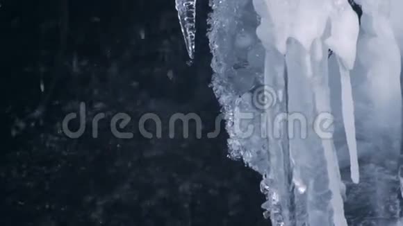 春天瀑布背景下的冰柱融化透明冰柱视频的预览图