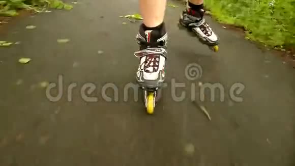 一个特写镜头的腿在白色滚筒那个人正在公园的柏油路上飞快地滑行视频的预览图