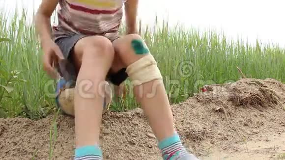 一个男孩坐在地上膝盖上放着一块绿漆视频的预览图