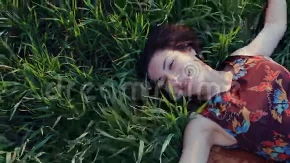 美丽的女孩躺在草地上视频的预览图