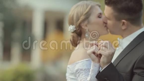 新娘和新郎展示他们的结婚戒指亲吻和视频的预览图