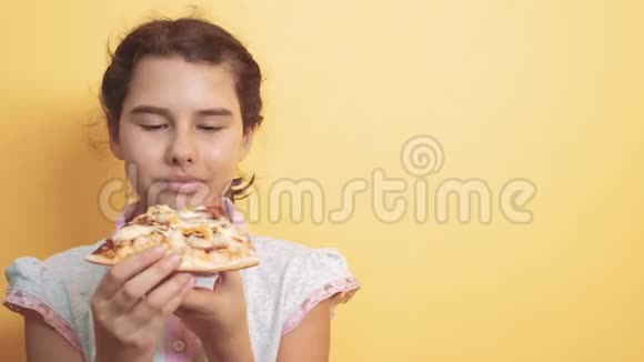 快乐的小女孩吃一片披萨的概念十几岁的孩子饿了吃一片披萨慢生活方式运动视频的预览图