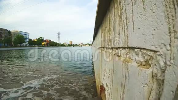 一条生锈的雨水排水管雨水从里面流入河流下水道里有污水视频的预览图