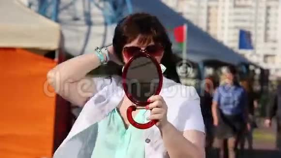 在街头集市上戴耳环的女人照照镜子视频的预览图