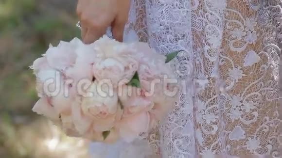 新娘手持婚礼花束新郎抚摸她的手视频的预览图