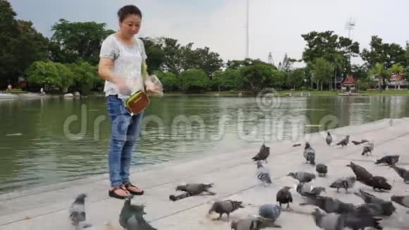亚洲女人和她的儿子在公园户外自然夏天鸟后射视频的预览图