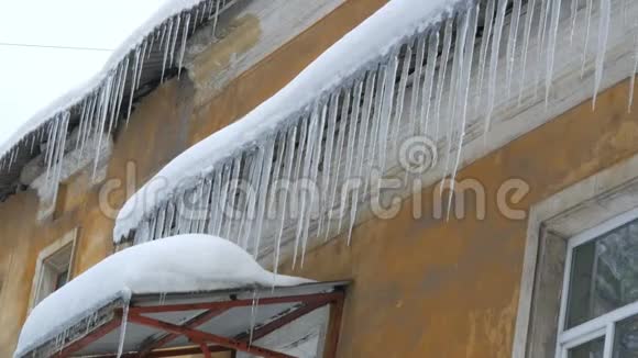 冬天房子屋顶上大量融化的冰柱视频的预览图