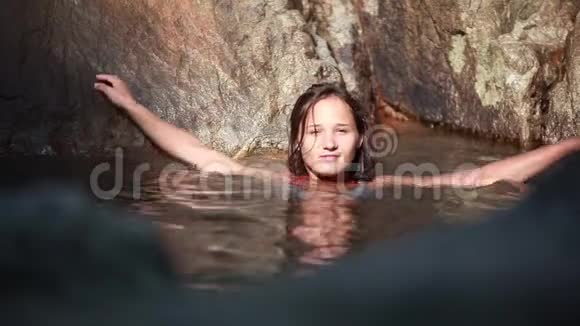 年轻美丽的女人在热带丛林的瀑布下在水中放松1920x1080视频的预览图