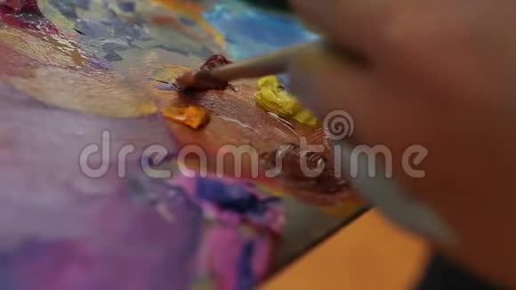 艺术家在调色板上混合油漆艺术在调色板上刷混合油漆艺术家在调色板上刷混合彩色油画视频的预览图
