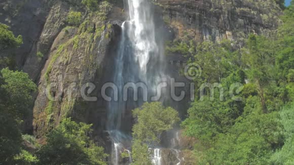 从高高的岩石悬崖和绿树瀑布视频的预览图