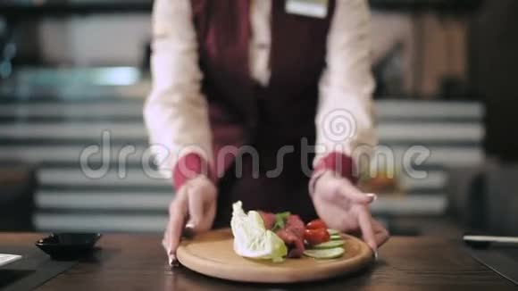 服务员把盘子里的食物送到烤架上视频的预览图
