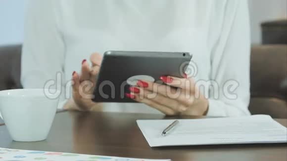 女人在咖啡馆里用数码平板电脑视频的预览图