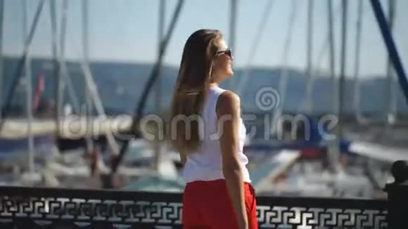 女子在码头附近的游艇背景蓝天选择性聚焦视频的预览图